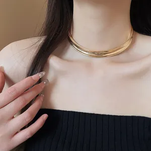 Vista dettagliata di un elegante girocollo in metallo dorato minimalista sulla modella
