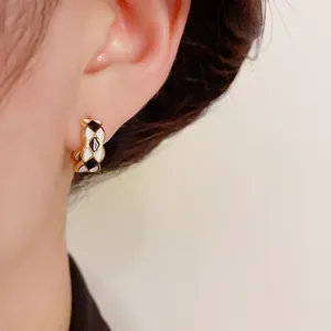 Elegant gold-plated checkered enamel hoop earrings with black and white rhombus pattern