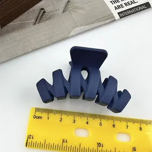 Pinza per capelli blu scuro opaca misurata con righello di circa 8 cm di lunghezza