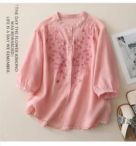 Detailed embroidery on a pink cotton linen shirt with stand-up collar and button-down front