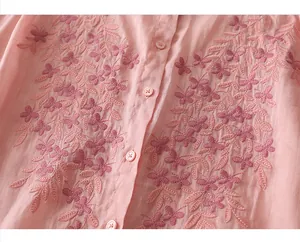 Close-up of floral butterfly embroidery and small pink buttons on linen cotton shirt