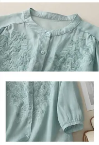 Close-up of intricate floral embroidery and button detail on mint cotton linen shirt