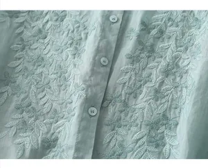 Macro detail of leaf embroidery and buttons on linen cotton mint green shirt