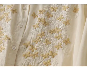 Detailed close-up of intricate butterfly floral embroidery on beige linen cotton shirt