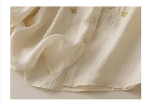 Detail of cream cotton linen shirt with delicate butterfly and botanical embroidery
