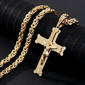Detailed close-up of a gold-tone cross pendant with Byzantine chain on a black stand