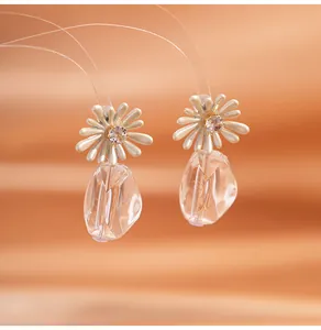 Detail showing white daisy flower earrings with pink crystal and clear pendant drop
