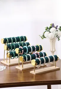 Three-tier green velvet jewelry stand with gold metal frame and solid wooden base