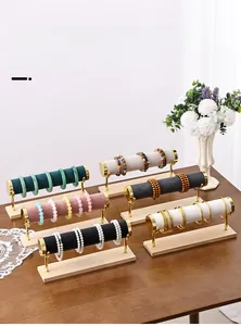 Detailed view of multi-color velvet bracelet stands with gold metal bars and wooden bases