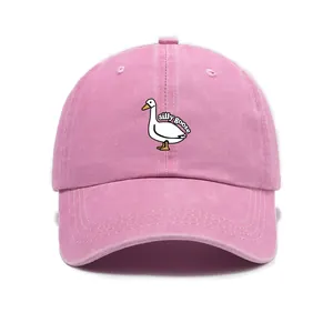 Detailed close-up of pink washed cotton baseball cap with white silly goose embroidery