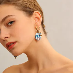 Nahaufnahme der Keramik-Tulpenohrringe mit blau-weißem Porzellanmuster am Model getragen