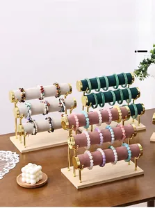 Close-up of multi-tier jewelry display stand with gold metal frame and wooden base