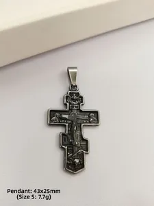 Détail macro du pendentif croix orthodoxe en acier titane avec icônes en relief