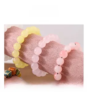 Detail presentation of beaded bracelets with jade-like texture on a pink velvet display