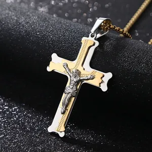 Close-up of stainless steel cross pendant with gold and silver tones and relief detail