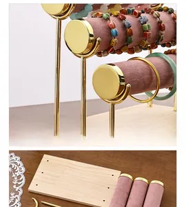 Three-tier pink velvet jewelry stand with gold metal frame and solid wood base detail