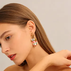 Detailaufnahme von Modell mit Keramik-Tulpenohrringen, Vintage-Goldhaken und Perlen