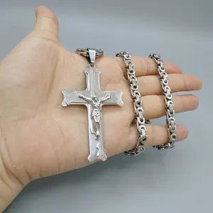 Macro shot of silver stainless steel cross pendant with detailed crucifix and thick chain