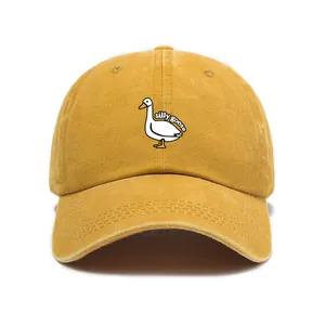 Detailed view of the silly goose embroidery on a mustard washed cotton baseball cap