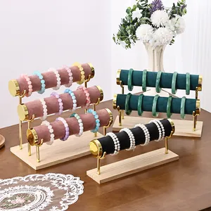 Multi-tier velvet jewelry display stand with gold metal bars and solid wood base