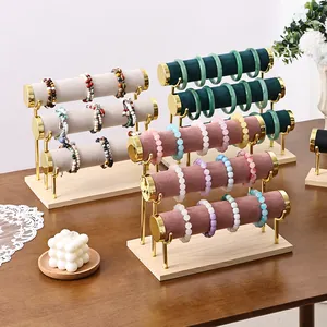 Three-tier velvet jewelry display stand with gold metal frame and solid wooden base