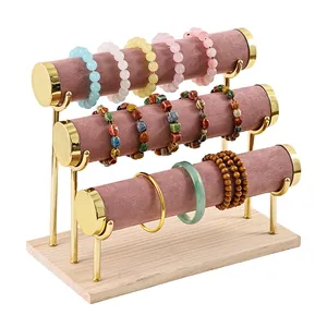 Three-tier jewelry display stand with wooden base and pink velvet bars for bracelets