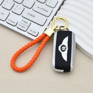 Custodia per chiavi auto in pelle nera con portachiavi a corda intrecciata arancione e oro