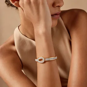 Elegant gold stainless steel bangle with pavé crystal interlocking teardrop design