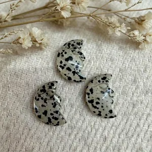 Natural moon stones pendants with hand-carved face profiles on woven background