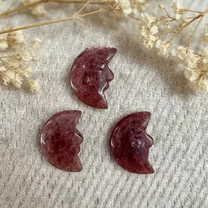 Macro shot of three hand-carved moon face pendants made of strawberry quartz gemstone