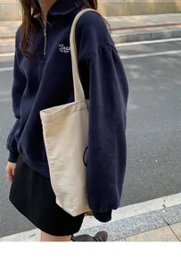 Detailed view of Jazz Corner embroidery on navy blue half-zip sweatshirt with polo collar