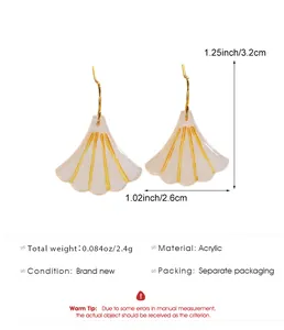 Macro view of white acrylic ginkgo leaf earrings with gold stripes and dimensions
