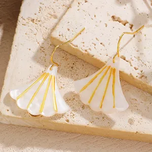 Detailed view of elegant ginkgo leaf earrings with white pearlescent finish and gold accents