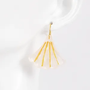Macro view of shell-shaped fan earring with pearlescent pink resin and gold accents