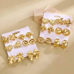 Detail of gold C-shaped earring sets featuring starfish, shells, and leaves on cards