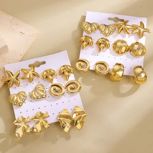 Detail of vintage gold-plated C-shape earring set with starfish and shell designs