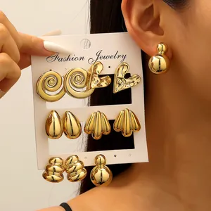 Detail of 5 pairs gold vintage C-shaped earrings with spiral and heart textured designs