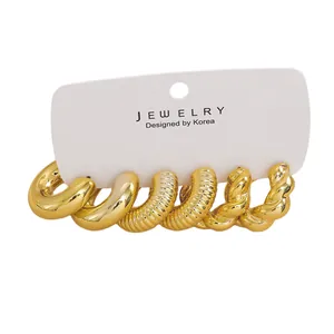 Detailed view of three gold-plated hoop earrings with smooth, ribbed and twisted textures