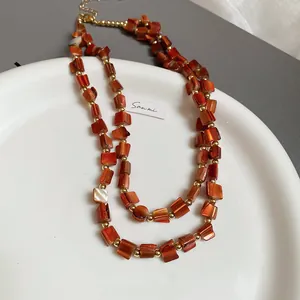 Elegante zweisträngige Halskette mit orangen Glasperlen und goldenen Akzenten