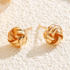 Detailed close-up showing the twisted knot texture of gold-plated geometric stud earrings