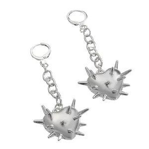 Gros plan de boucles d'oreilles punk argentées avec cœurs à pointes et fines chaînes