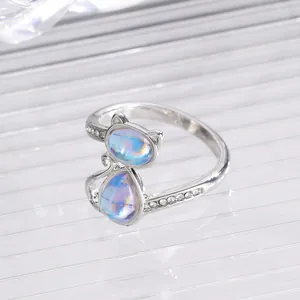 Close-up of silver cat ring with iridescent opals and sparkling zircon stones
