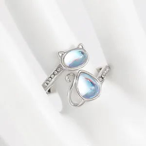 Detail of adjustable silver cat paw ring featuring iridescent opal stones and small zircon accents