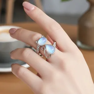Detail view of adjustable silver cat paw ring featuring blue moonstone and fine zircons