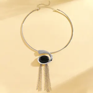 Detail of silver choker with oval black stone pendant and delicate metal tassels