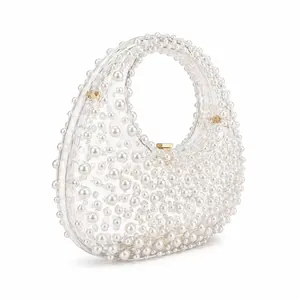 Elegant clear acrylic crescent handbag with white pearl embellishments and gold clasp