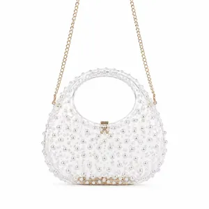 Macro detail of transparent acrylic bag with inlaid white pearls and gold metal lock