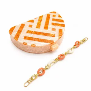 Modern semicircular acrylic clutch bag with orange and white marble stripes and gold chain