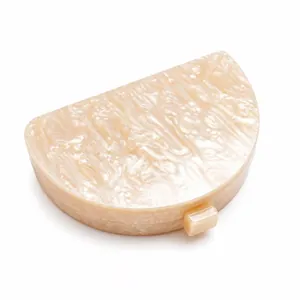 Detailed macro view of cream acrylic semi-circle clutch with pearlescent marble texture