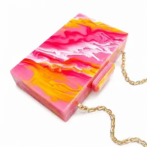 Acrylic evening clutch with pink marble texture, golden chain strap, and rectangle clasp